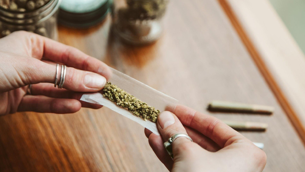 Many US Companies to Stop Screening New Hires for Cannabis Use: A woman's hands as she's rolling a marijuana joint