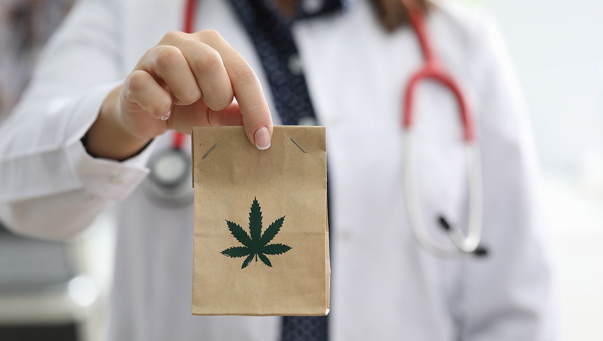 Mississippi, USA, Has Legalized Medical Cannabis: A woman doctor holding a plain brown paper bag with a cannabis leaf logo Mississippi, USA, Has Legalized Medical Cannabis: A woman doctor holding a plain brown paper bag with a cannabis leaf logo