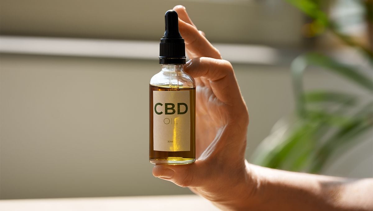 Weed in Florida: Cannabis Legal Status Guide: A person's hand demonstrating a CBD bottle